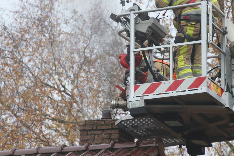 Brandweer veegt schoorsteen na brand