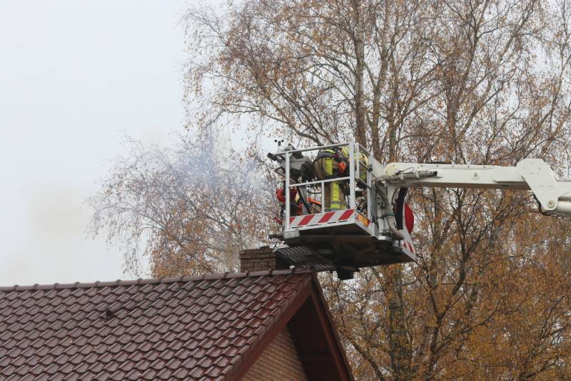 Brandweer veegt schoorsteen na brand