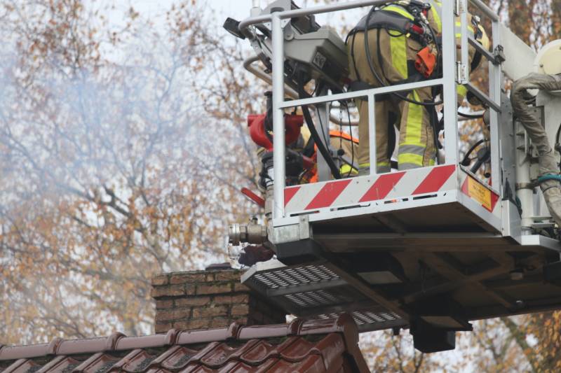 Brandweer veegt schoorsteen na brand
