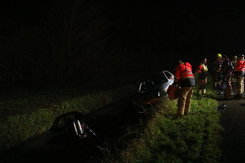 Auto raakt van dijk, brandweer doorzoekt sloot