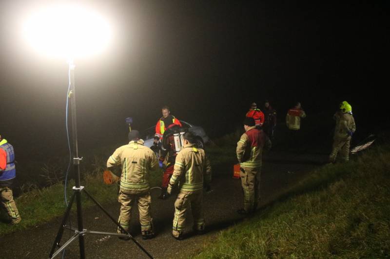 Auto raakt van dijk, brandweer doorzoekt sloot