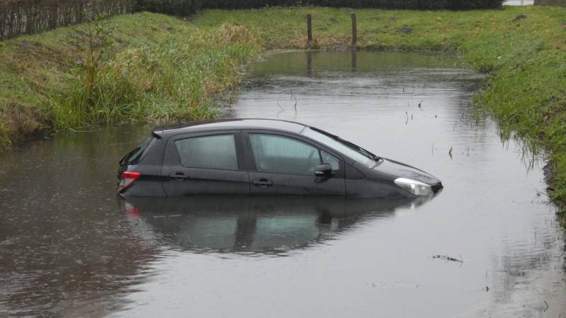 Auto achteruit de sloot in