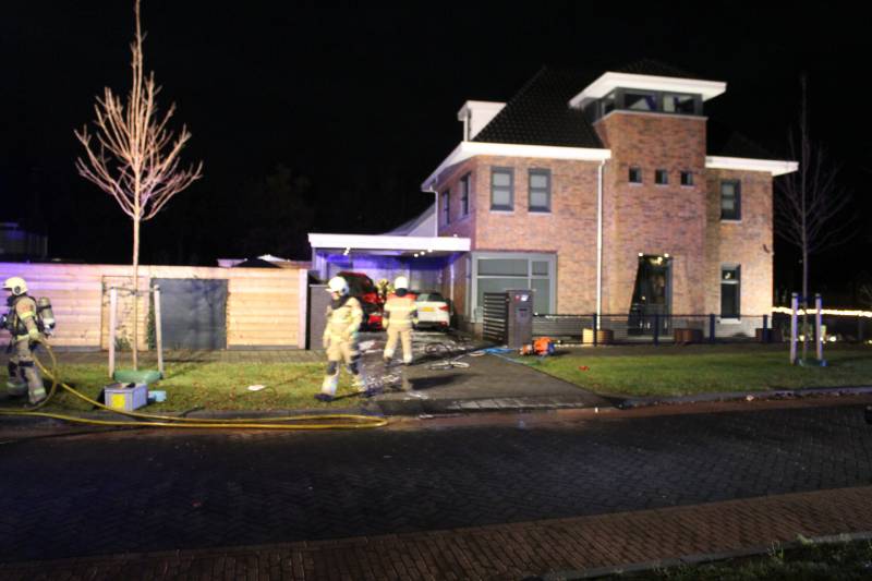 Auto in de brand onder carport