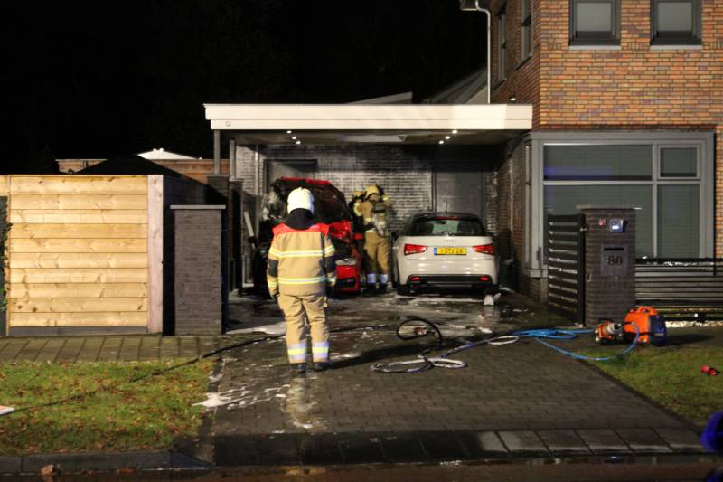 Auto in de brand onder carport