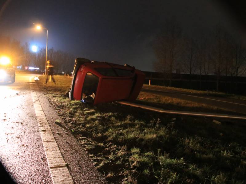 Auto op zijn kant, bestuurder gewond