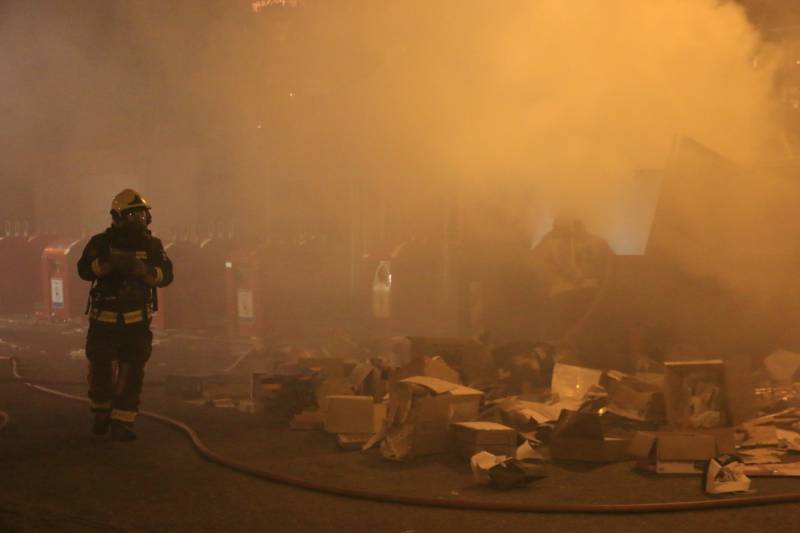 Brandweer druk met brand in container vol karton