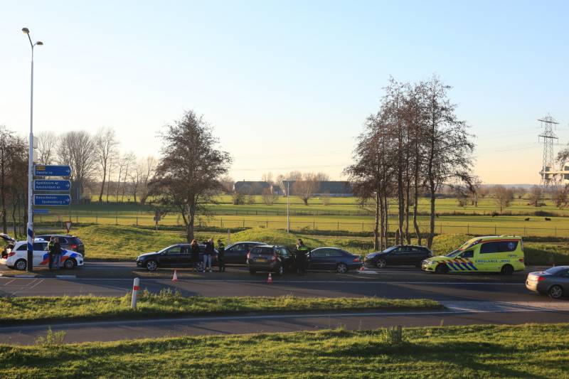 Twee personenauto's botsen op elkaar op rotonde