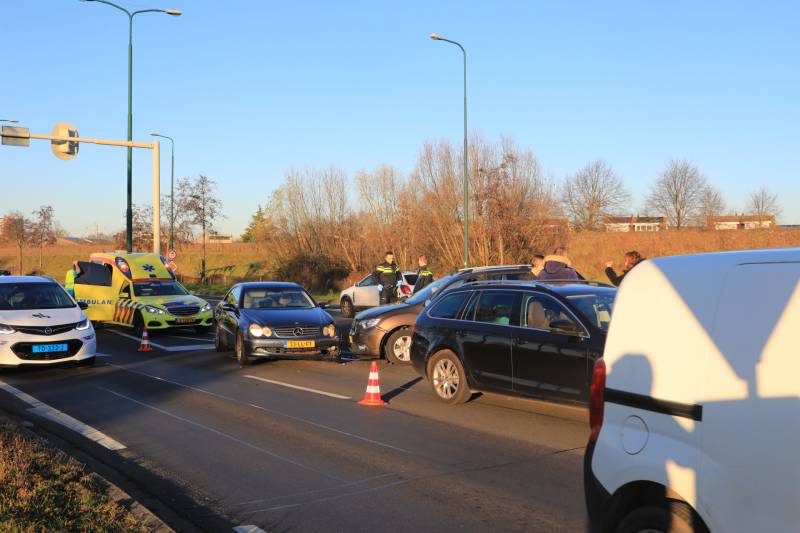 Twee personenauto's botsen op elkaar op rotonde