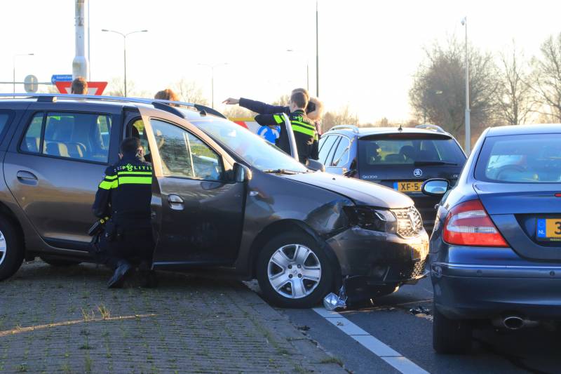 Twee personenauto's botsen op elkaar op rotonde
