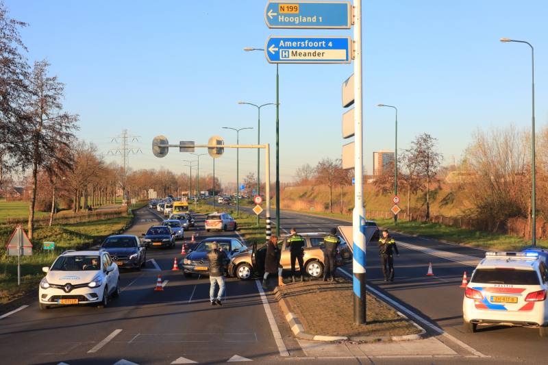 Twee personenauto's botsen op elkaar op rotonde