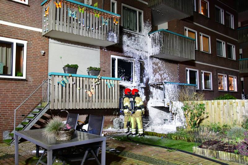 Brandweer blust brand onder balkon