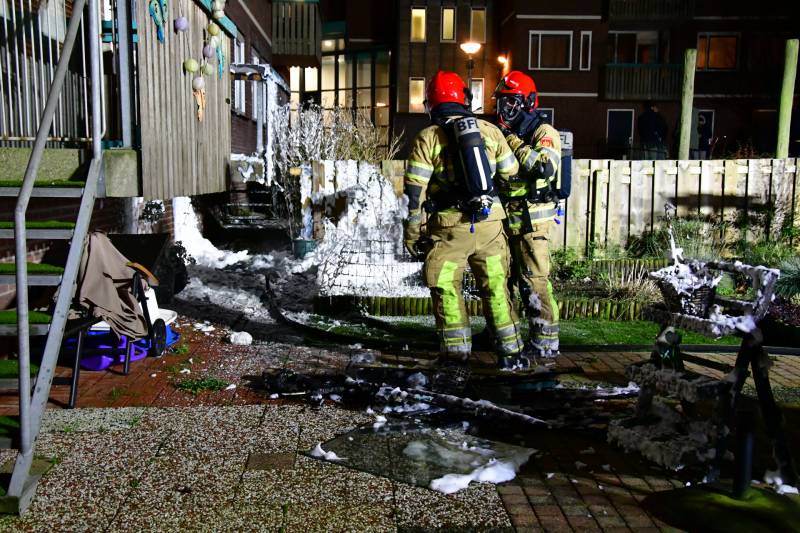 Brandweer blust brand onder balkon