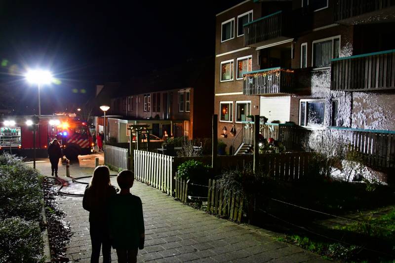 Brandweer blust brand onder balkon