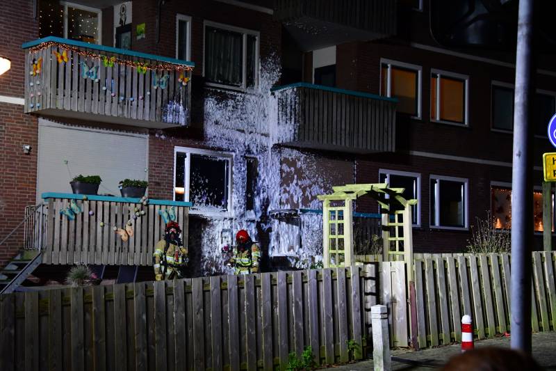 Brandweer blust brand onder balkon