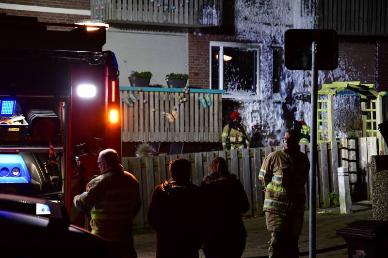 Brandweer blust brand onder balkon