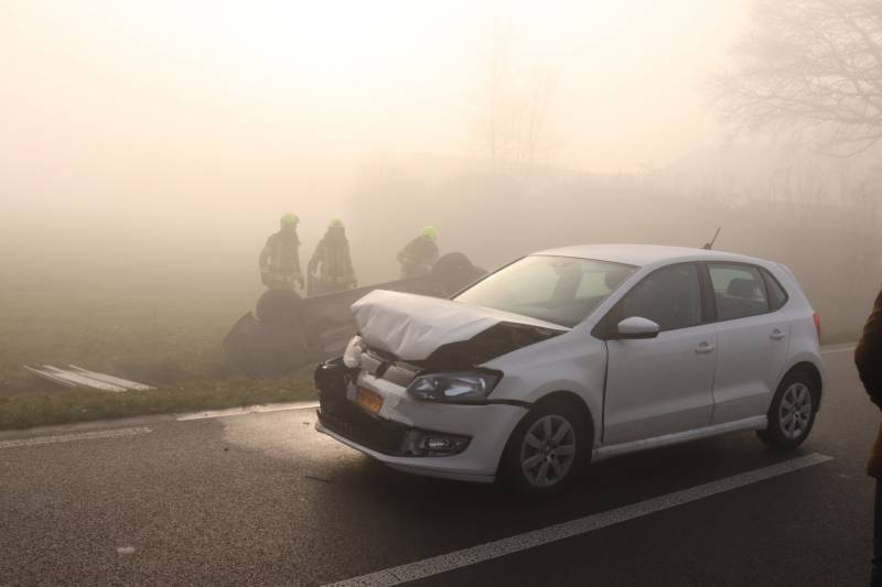 Auto op kop in sloot na botsing met andere auto