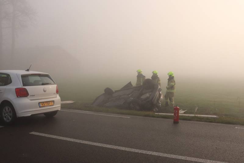 Auto op kop in sloot na botsing met andere auto