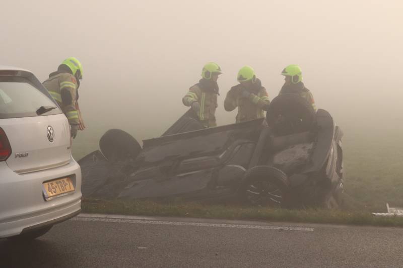 Auto op kop in sloot na botsing met andere auto