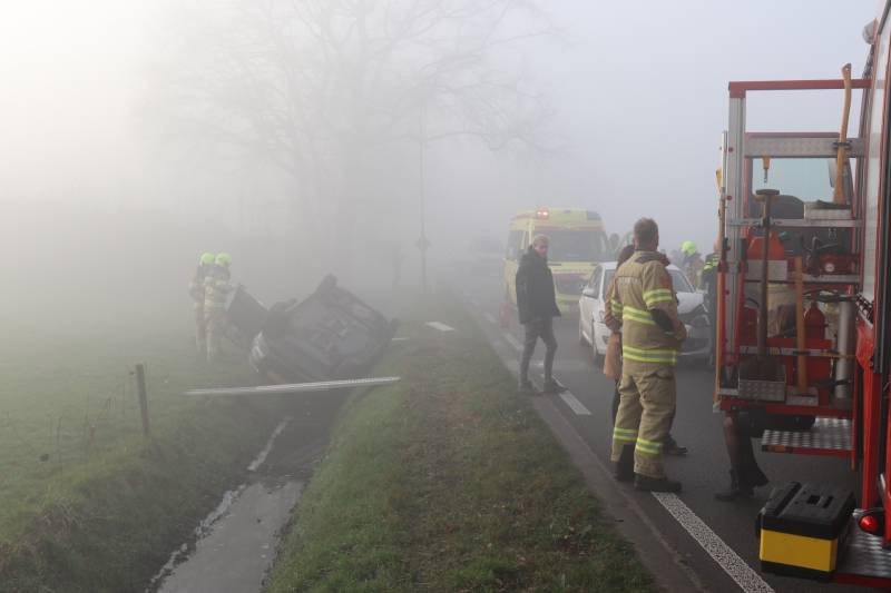 Auto op kop in sloot na botsing met andere auto