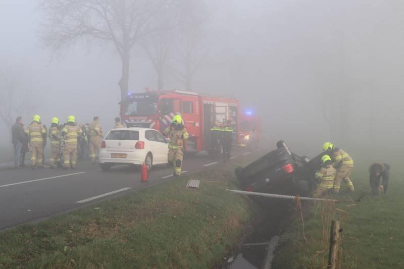 Auto op kop in sloot na botsing met andere auto