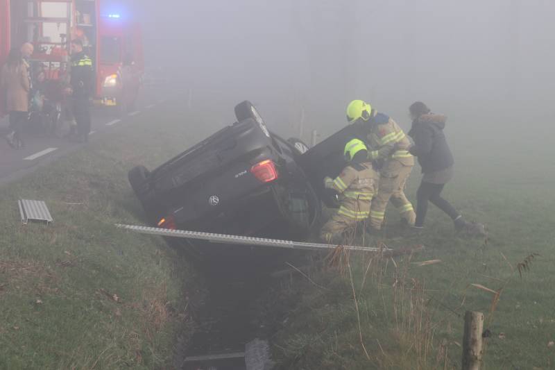 Auto op kop in sloot na botsing met andere auto
