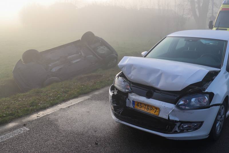 Auto op kop in sloot na botsing met andere auto