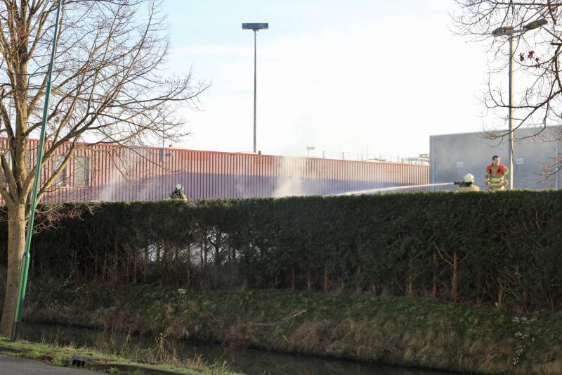 Dikke rookwolken door brand in coniferenhaag