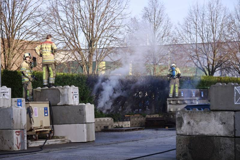 Dikke rookwolken door brand in coniferenhaag