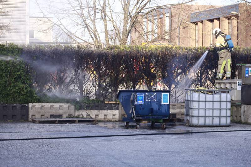 Dikke rookwolken door brand in coniferenhaag