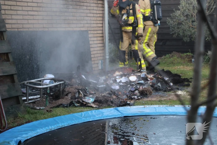Brandweer blust afvalcontainer in tuin