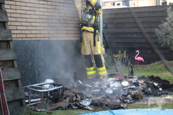Brandweer blust afvalcontainer in tuin