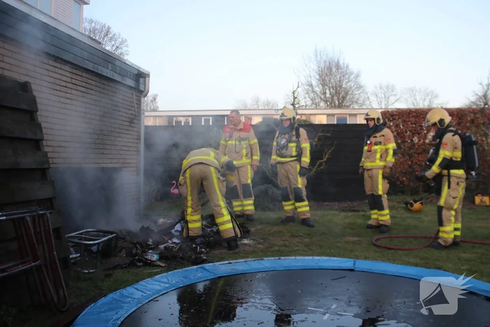 Brandweer blust afvalcontainer in tuin