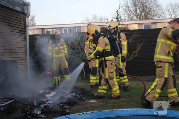 Brandweer blust afvalcontainer in tuin