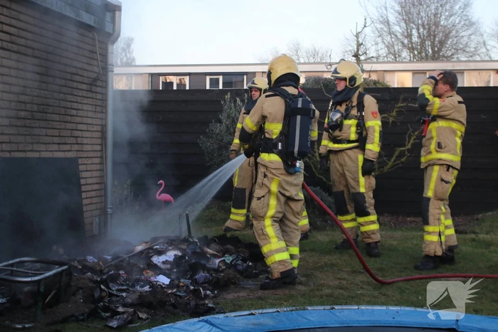 Brandweer blust afvalcontainer in tuin