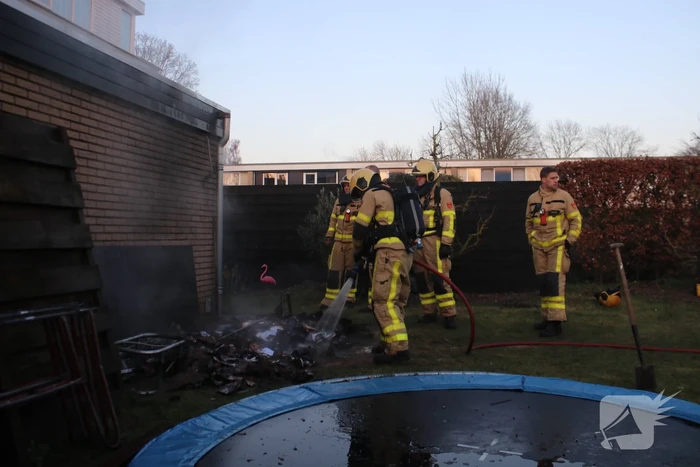 Brandweer blust afvalcontainer in tuin