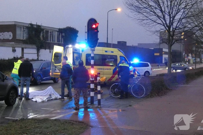 Personenauto schept wielrenner