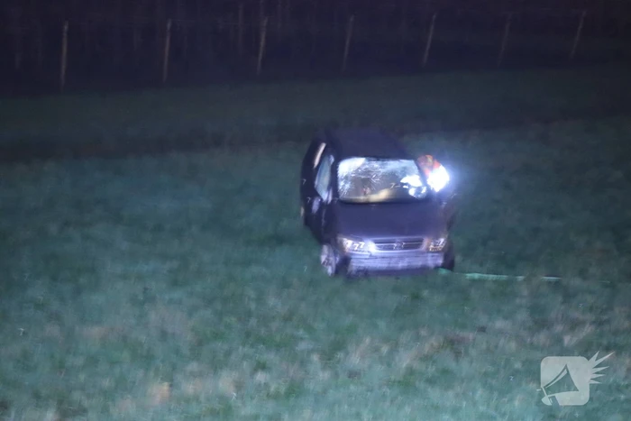 Auto vliegt uit de bocht op afrit en belandt in weiland