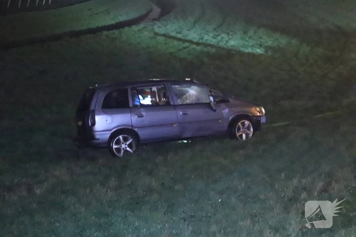 Auto vliegt uit de bocht op afrit en belandt in weiland