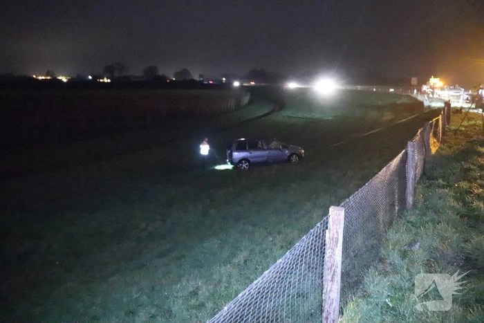 Auto vliegt uit de bocht op afrit en belandt in weiland