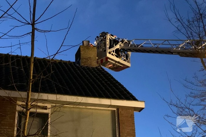 Brandweer controleert schoorsteenbrand met hoogwerker