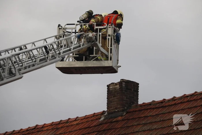 Brandweer veegt schoorsteen na brand