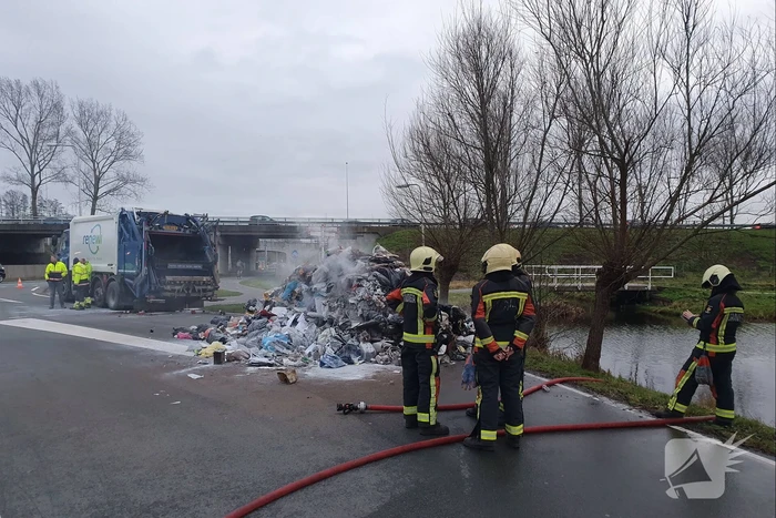 Vuilniswagen kiept smeulend afval op straat