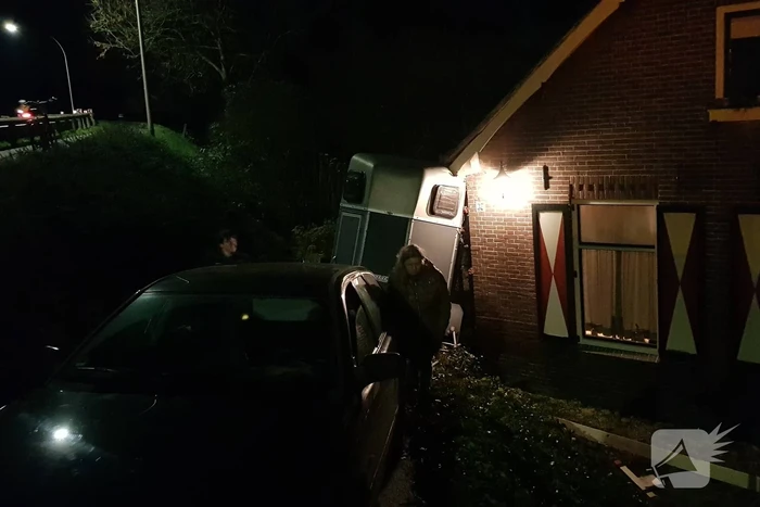 Auto met paardentrailer botst tegen huis.