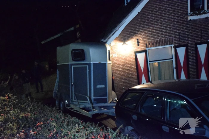 Auto met paardentrailer botst tegen huis.