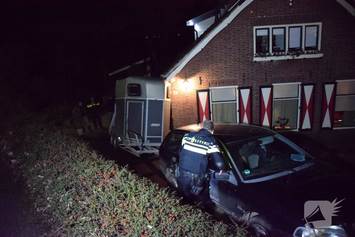 Auto met paardentrailer botst tegen huis.