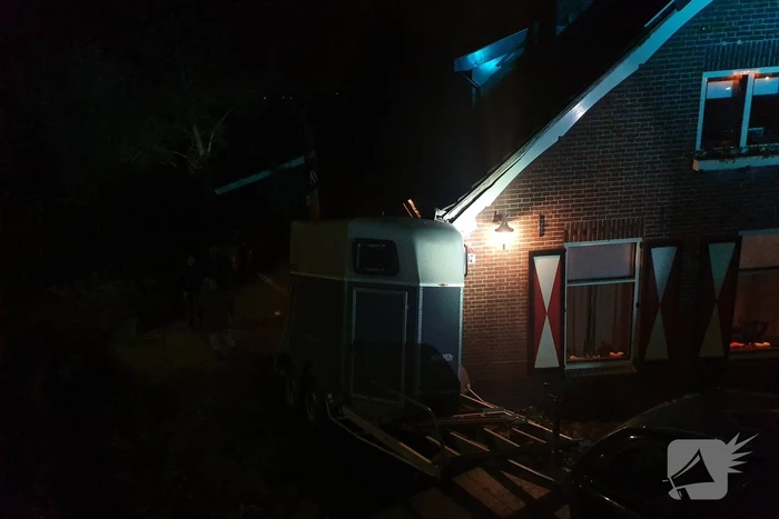 Auto met paardentrailer botst tegen huis.