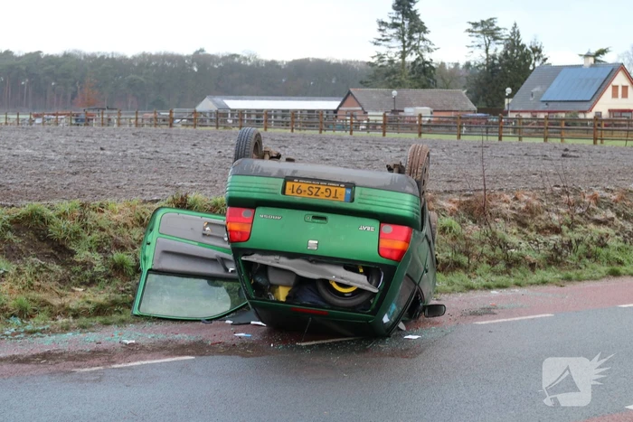 Auto vliegt over de kop op spekgladde weg