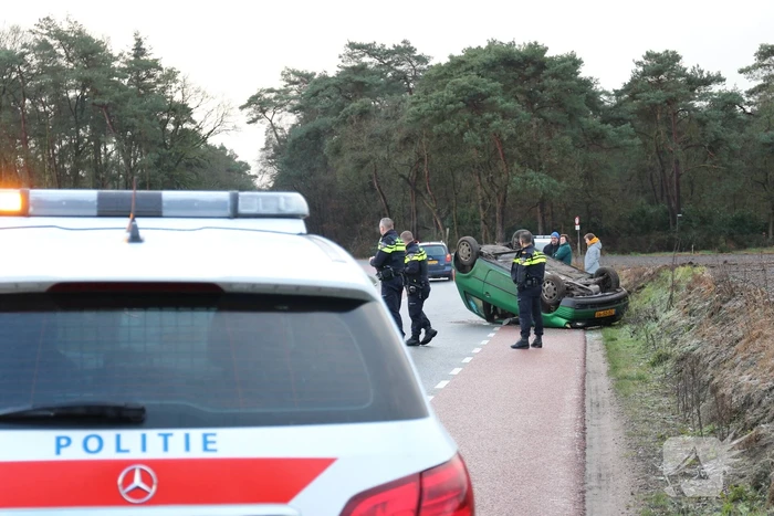 Auto vliegt over de kop op spekgladde weg