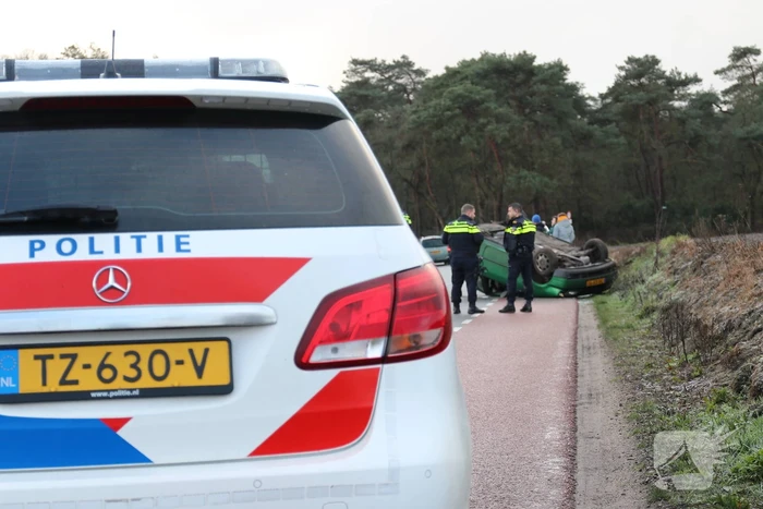 Auto vliegt over de kop op spekgladde weg