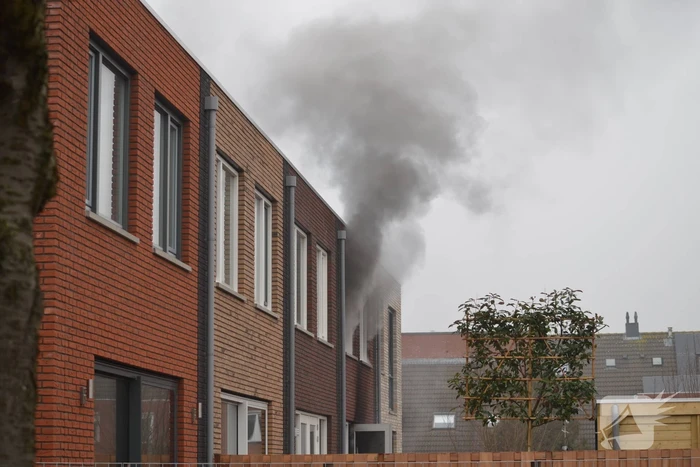 Dikke rookpluimen bij brand in woning